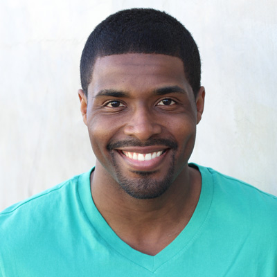 A man and a woman, both smiling, posing for a photo with their arms around each other.