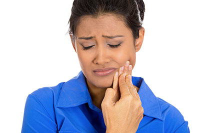 A woman with a concerned expression, holding her finger to her mouth.