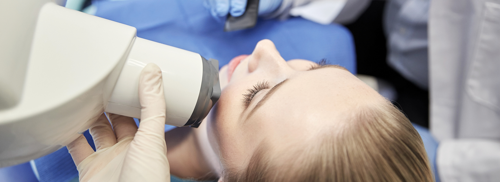 A person receiving dental care, with a dentist using advanced technology to examine their teeth.