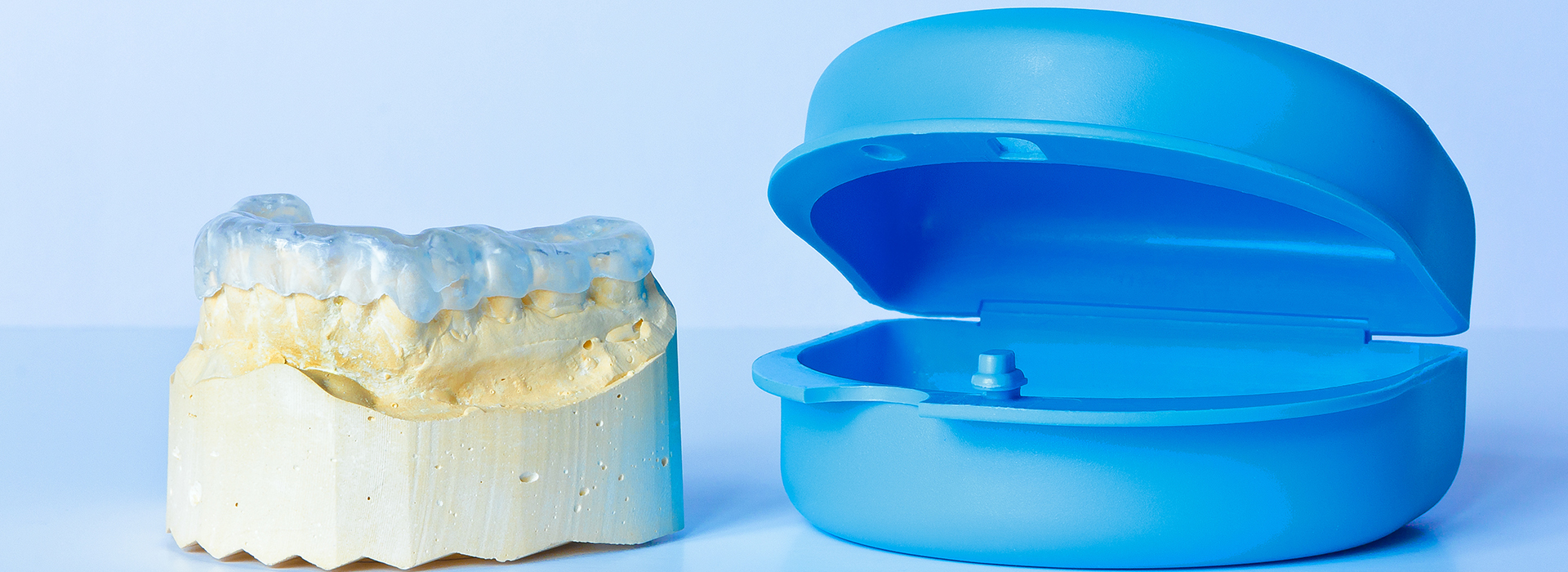 The image shows a blue dental impression tray alongside a yellow dental impression material.