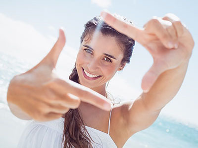 A woman is taking a selfie with her hand and finger pointed towards the camera.